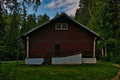 Exterior of house amidst trees and building against sky