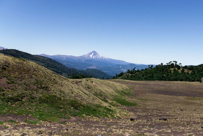 Scenic view of mountains against clear blue sky