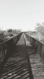 Wooden footbridge against clear sky