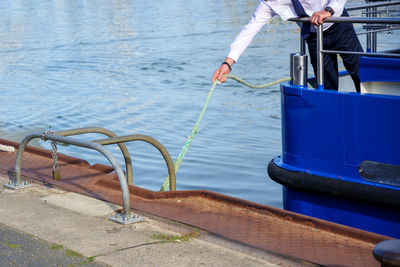 Low section of person on railing against sea