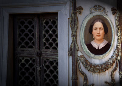 Portrait of a woman against door in building