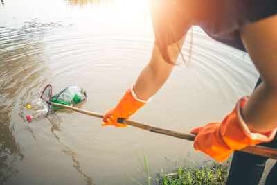 Midsection of woman cleaning lake