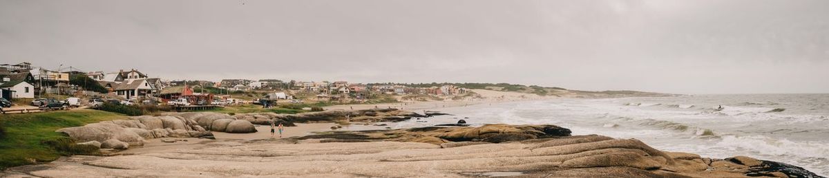 Panoramic view of sea and buildings against sky