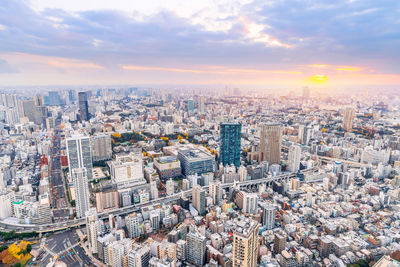 High angle view of city buildings against sky during sunset