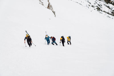 People skiing on snow covered landscape