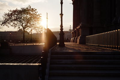 Steps leading towards buildings against sky during sunset