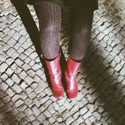 Low section of woman standing on sidewalk