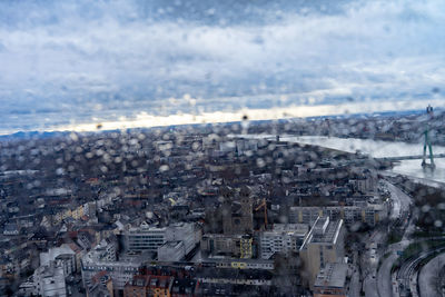 High angle view of townscape by sea against sky