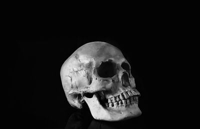 Close-up of human skull against black background