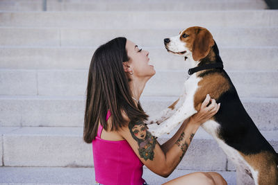 Rear view of woman with dog against people