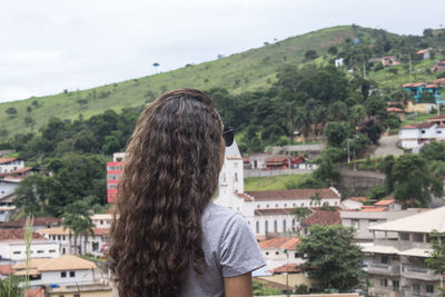 Rear view of woman standing against townscape