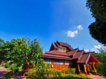 Temple by building against blue sky