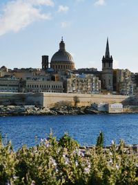 View of sea and buildings against sky