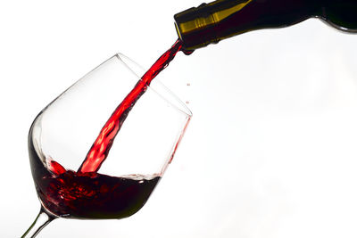 Close-up of wine glass bottle against white background