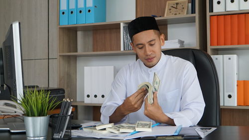 Portrait of young man working in office