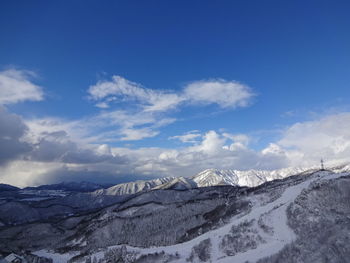 Scenic view of snowcapped mountains against blue sky