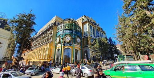 People on street against buildings in city