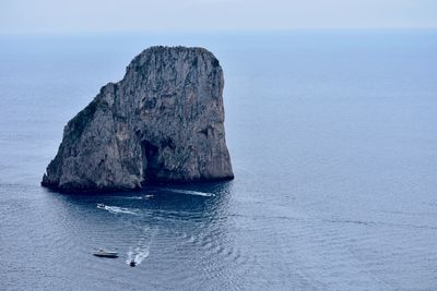 Rock formation in sea against sky