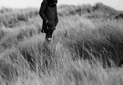 Midsection of person standing on grassy field