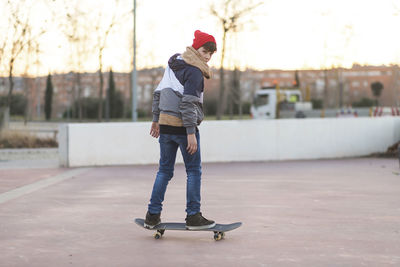 Full length of man skateboarding on skateboard in city