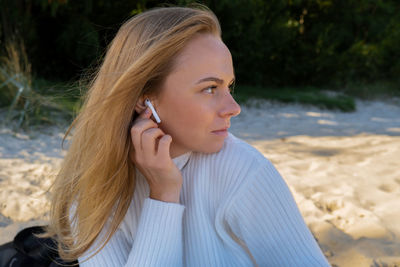 Young woman looking away while standing outdoors