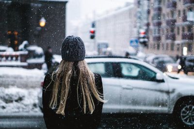 Rear view of woman in car during winter