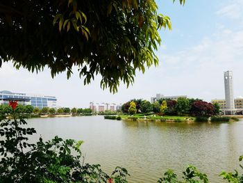 Scenic view of river by buildings against sky