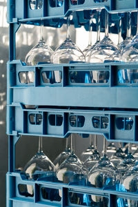 Blue plastic boxes with shiny wineglasses for restaurant standing upside-down and reflecting light