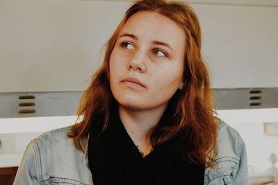 Close-up of thoughtful young woman against window