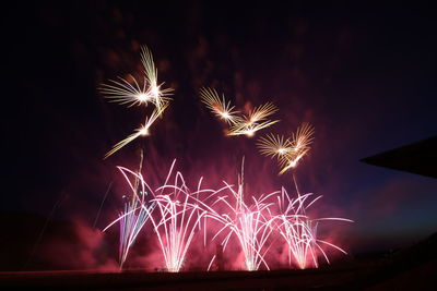 Low angle view of firework display at night