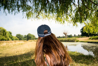 Rear view of woman with long brown hair resting at park