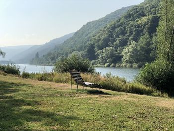 Scenic view of river by mountains against sky