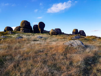 Rocks on field against sky