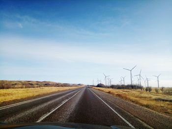 Road by landscape against sky