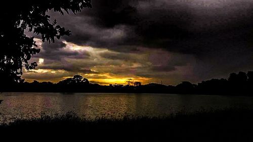 Scenic view of sea against cloudy sky at sunset