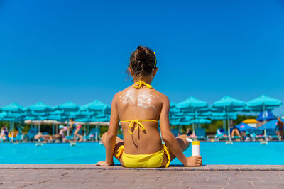 Rear view of woman standing at beach