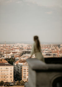 Close-up of sculpture against buildings in city