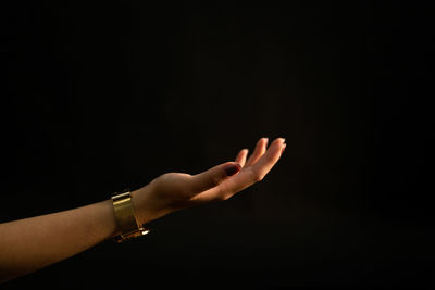 Midsection of woman hand against black background