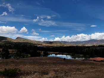 Scenic view of lake by mountains against sky