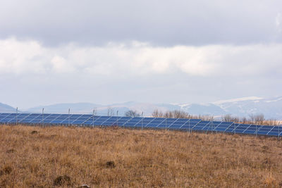 Scenic view of solar panels on field against sky