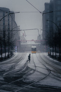 Man walking on street in city during winter