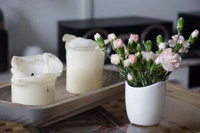 Close-up of white roses in vase on table at home