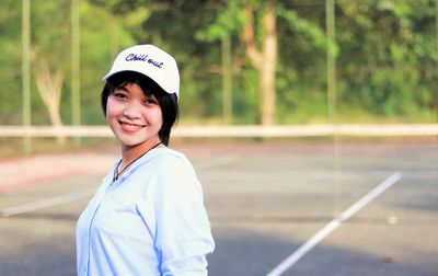 Portrait of a smiling young woman standing on road
