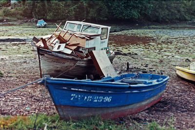 Abandoned boats moored in lake