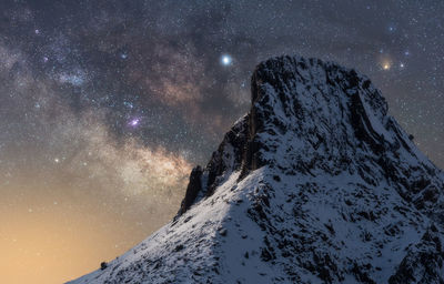 Scenic view of snowcapped mountains against sky at night