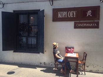 Woman sitting in front of building