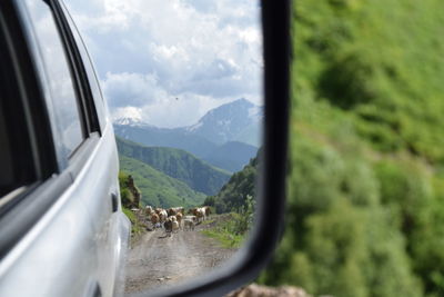 Panoramic shot of car on road amidst mountains against sky