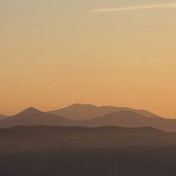 Scenic view of silhouette mountains against sky during sunset