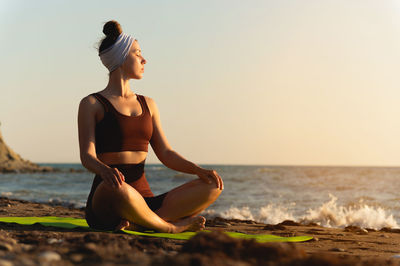 Young woman sitting on beach
