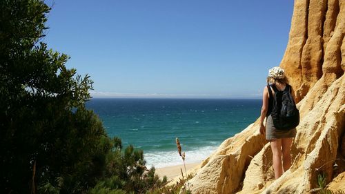 Woman looking at sea against clear sky